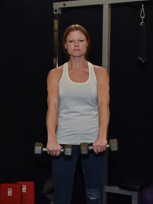 Michelle demonstrates Dumbbell Front Raise before raise.