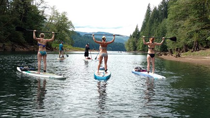 Michelle and friends present muscle toned shoulders and backs in SUP paddle extension exercise on Lake Merwin.